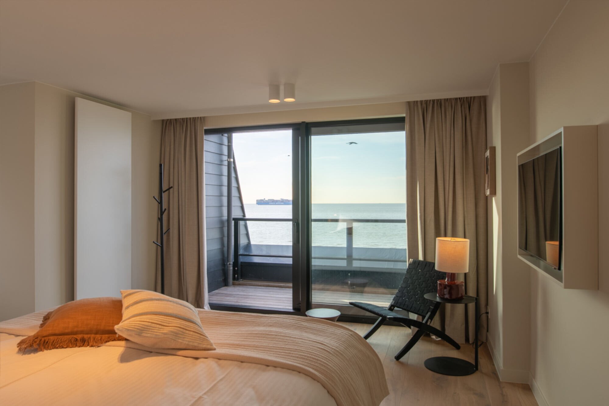 Hotel room with double bed and balcony overlooking the sea.