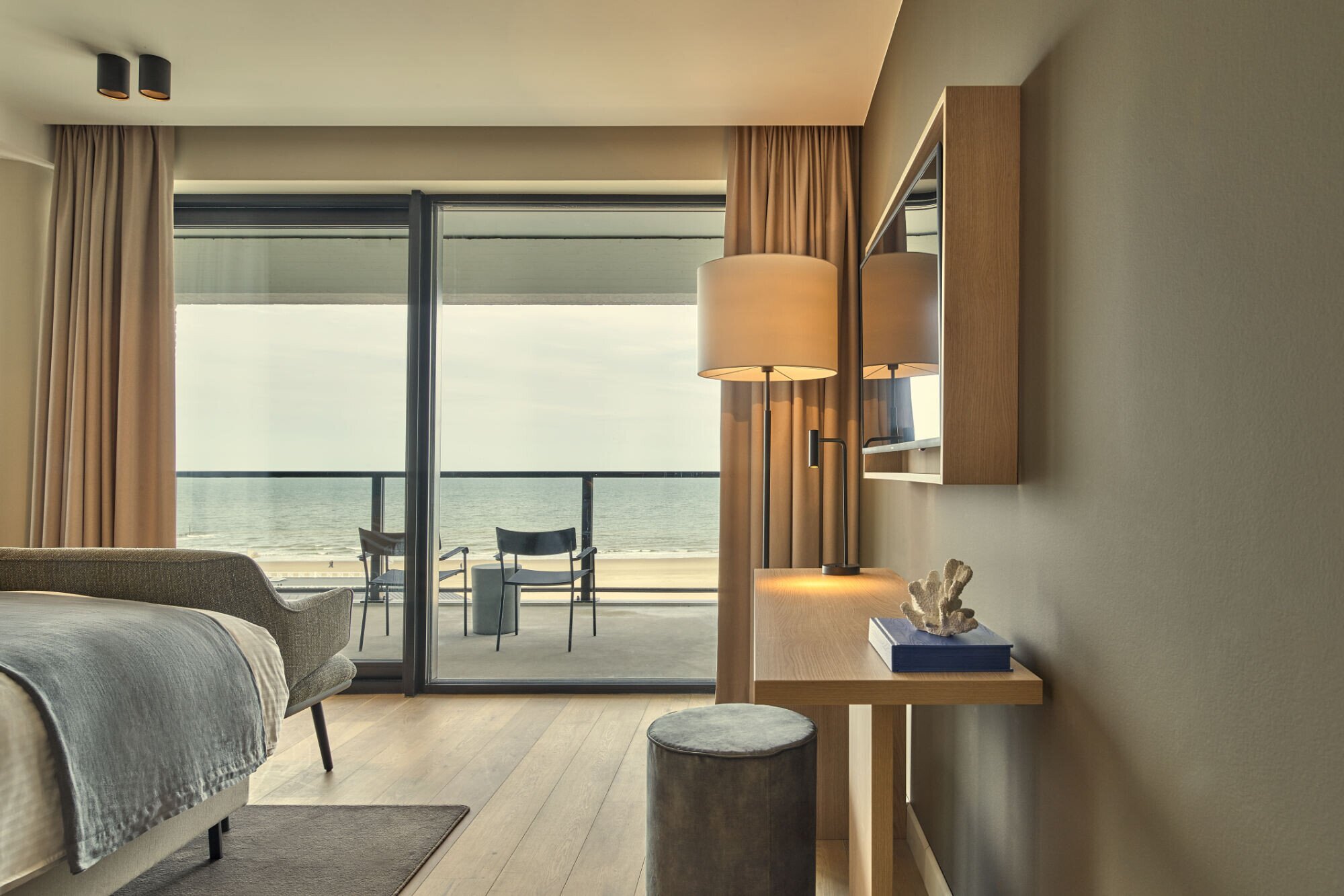 Suite with seating area and sea-view balcony at Hotel De Blanke Top.