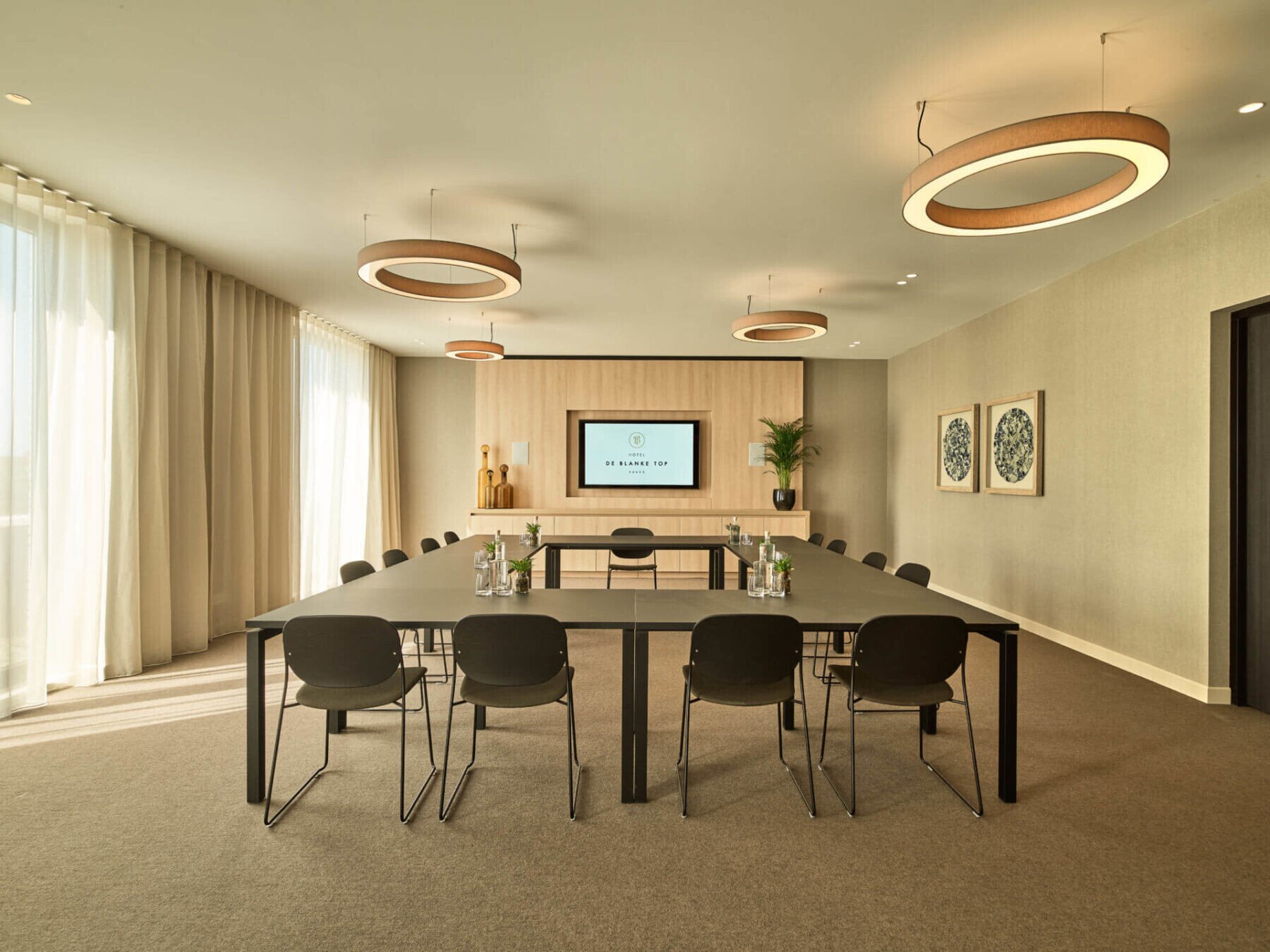 Zwartepolder meeting room in boardroom setup with round pendant lights.